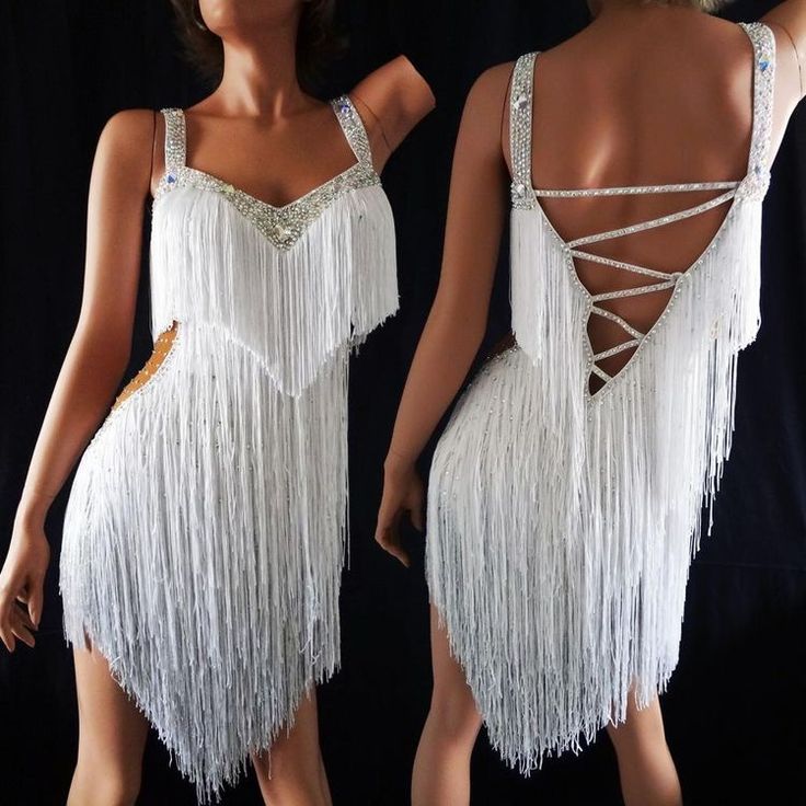 the back of a woman's dress with white fringes and beads on it