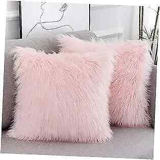 two pink fluffy pillows sitting on top of a couch