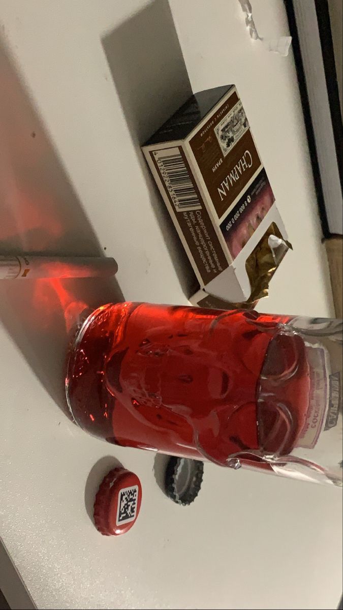 a bottle of alcohol sitting on top of a sink next to a toothbrush holder