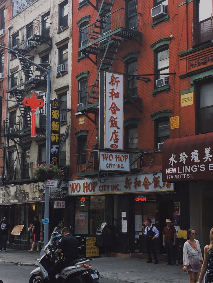 a motorcycle parked in front of a tall building with chinese writing on it's side