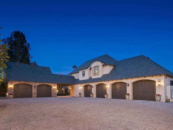 a large house with two garages and lights on