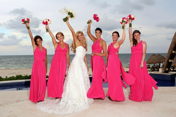 a group of women standing next to each other on top of a beach