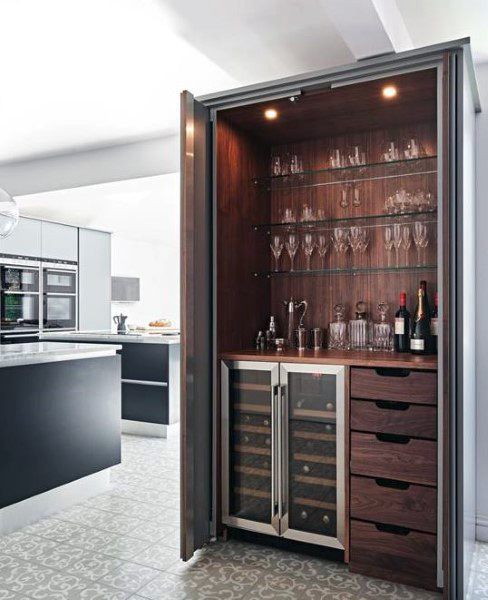 an open cabinet with wine glasses and bottles in it