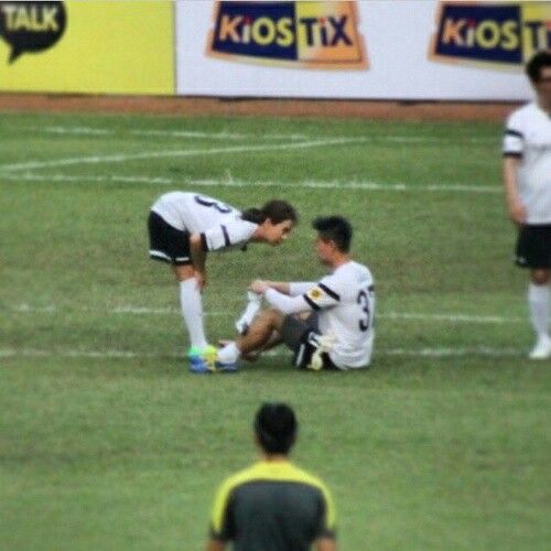 two soccer players are sitting on the field