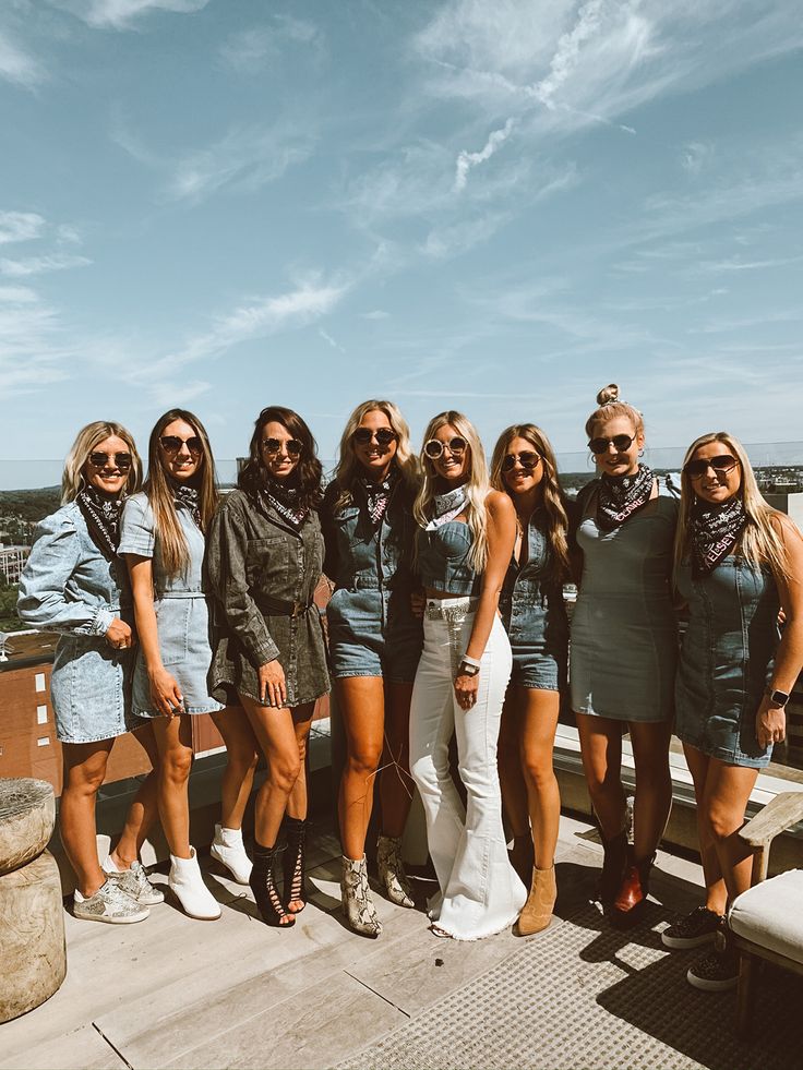 a group of women standing next to each other on top of a building