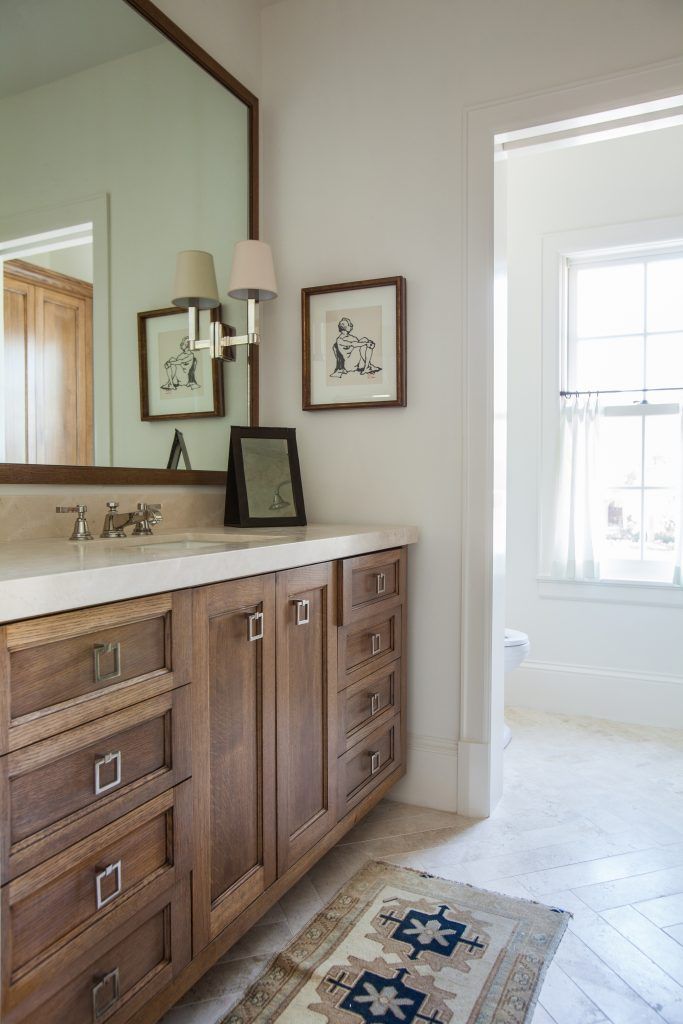 a bathroom with two sinks, mirrors and pictures on the wall