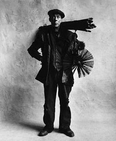 an old photo of a man holding a fan and wearing a hat with his arms stretched out