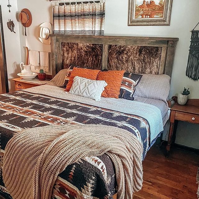 a bedroom with a bed, nightstands and pictures on the wall above it is decorated in native american style