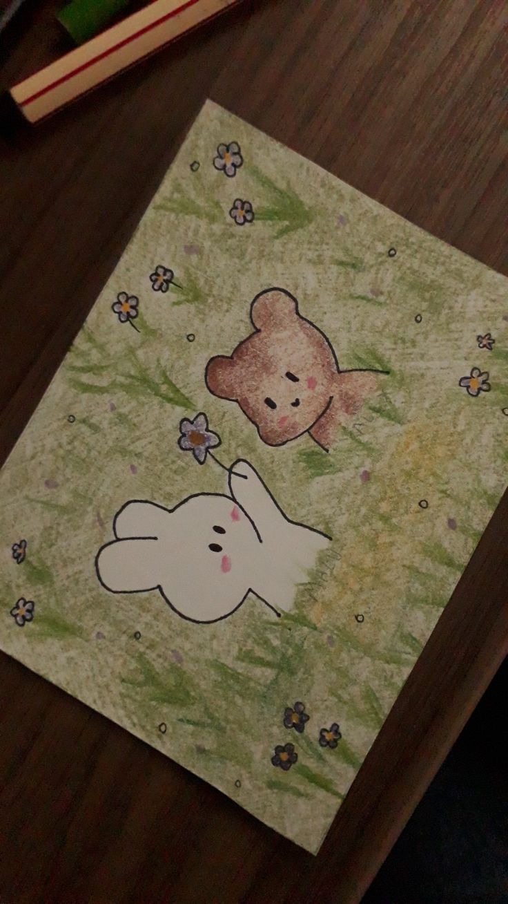 a card with a teddy bear and bunny on it sitting on a table next to a book