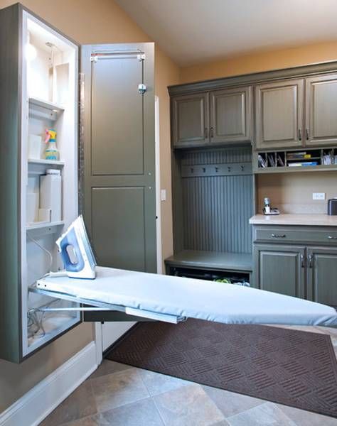 an ironing board is in the middle of a room with cabinets and cupboards