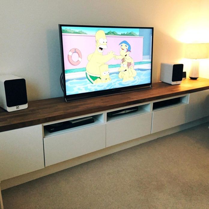 a flat screen tv sitting on top of a wooden entertainment center in a living room