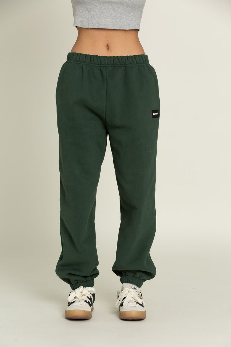 Elevate your athleisure style and feel like you're lounging on the go with our Hunter Green GH Jogger Sweatpants. The elastic waistband and tapered leg style allows you to feel secure and trendy. Complete with dual side pockets to keep your essentials close by. Pair with ur Hunter Green GH Cropped Hoodie to complete the set. Athleisure Style, Green Joggers, Tennis Skirts, Athleisure Fashion, Athletic Top, Yoga Tops, Jogger Sweatpants, Hunter Green, Cropped Hoodie