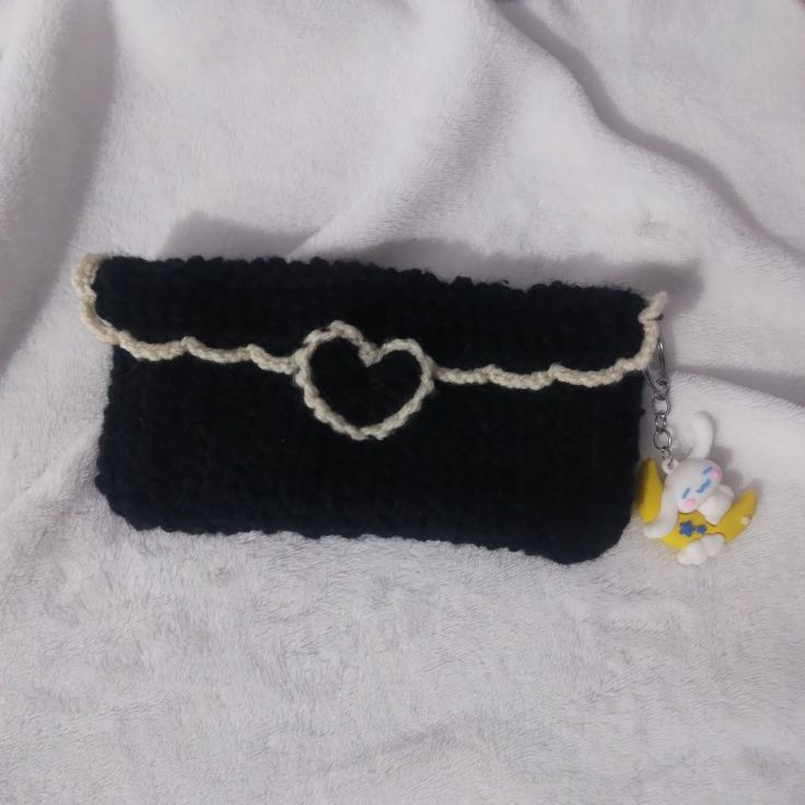 a black purse with a white heart on it