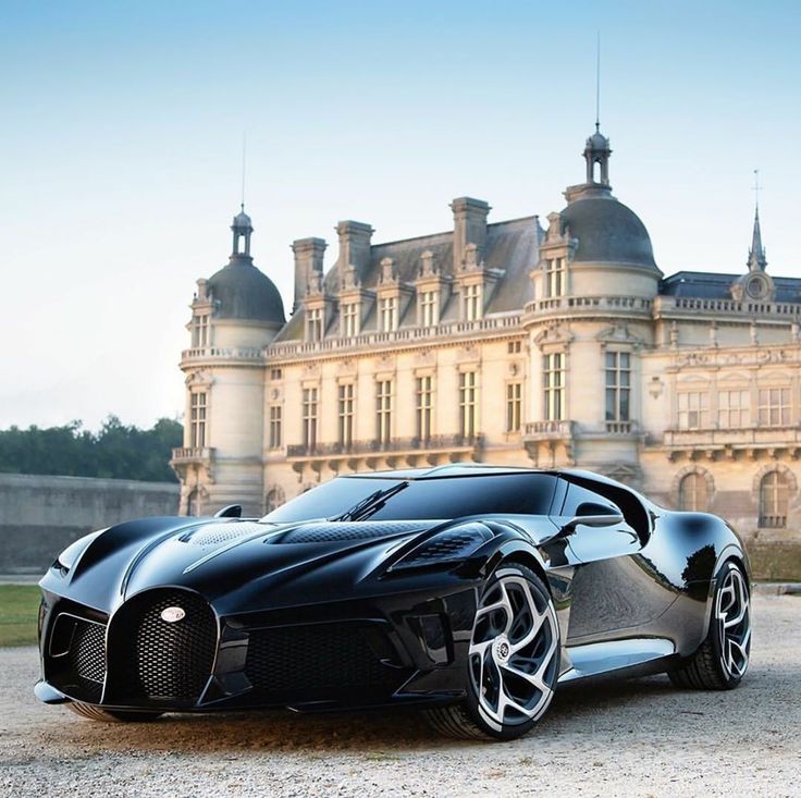 a black bugatti is parked in front of a large building with a clock tower