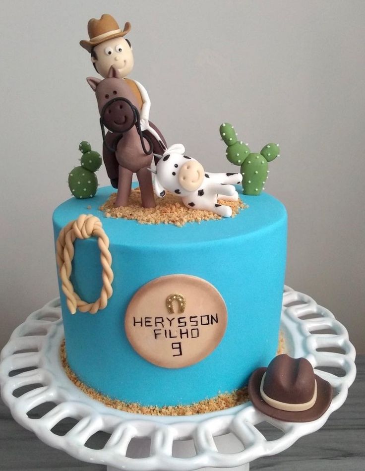 there is a blue cake with a cowboy on it