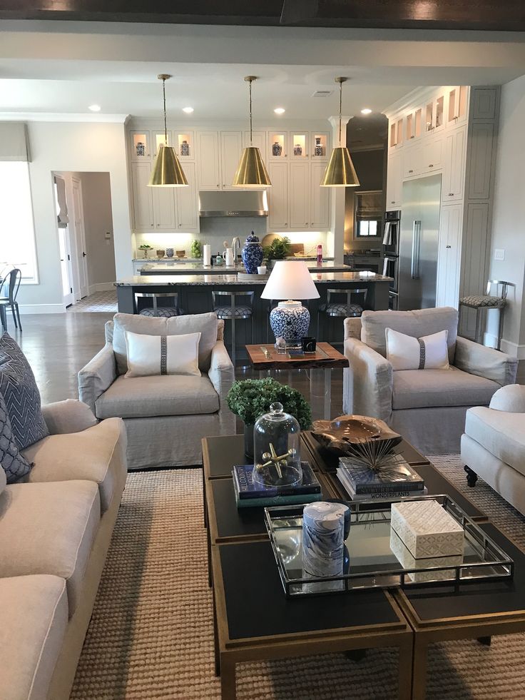 a living room filled with furniture and a kitchen in the backgroung area