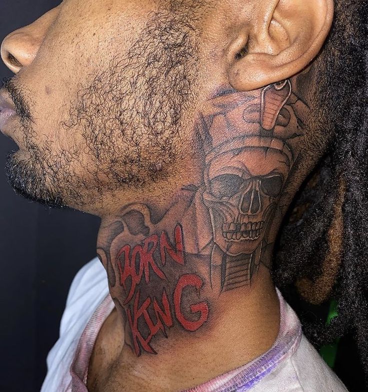 a man with a tattoo on his neck is looking to the side while wearing dreadlocks