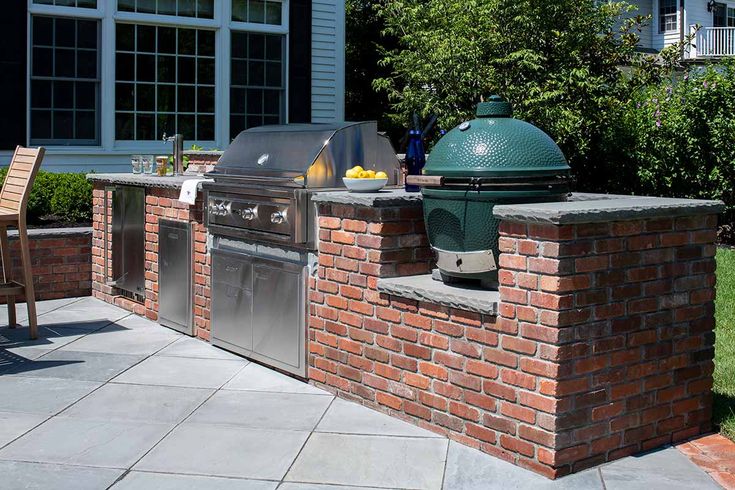 an outdoor bbq and grill with chairs around it