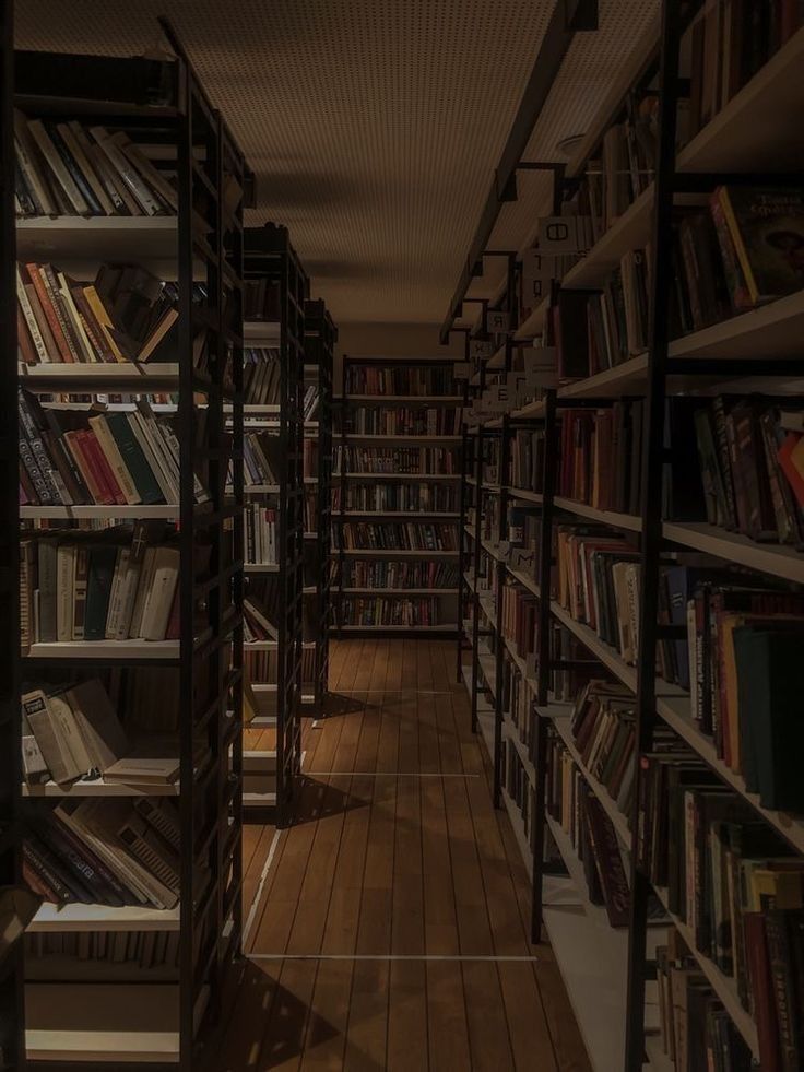 a long row of bookshelves filled with lots of books on wooden flooring