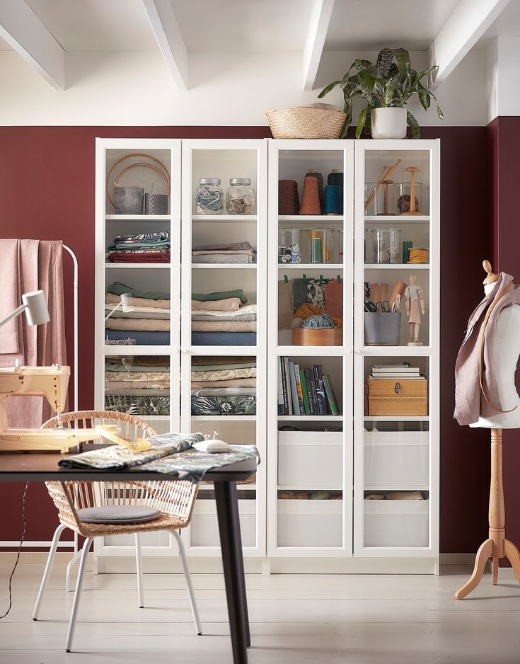 a room with a table, chair and bookcase full of books on it's shelves