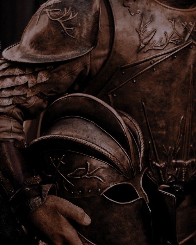 a close up of a man in armor holding a helmet