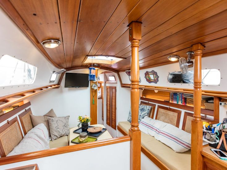 the interior of a boat with wood trimming and white walls, wooden flooring