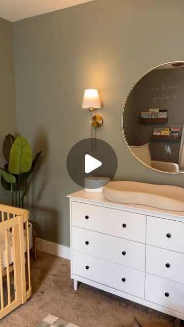 a baby's room with a crib, dresser and mirror on the wall