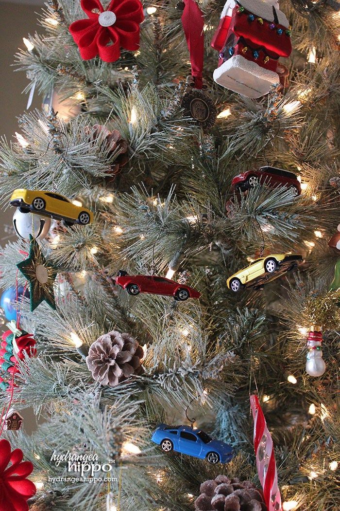 a christmas tree decorated with cars and pine cones