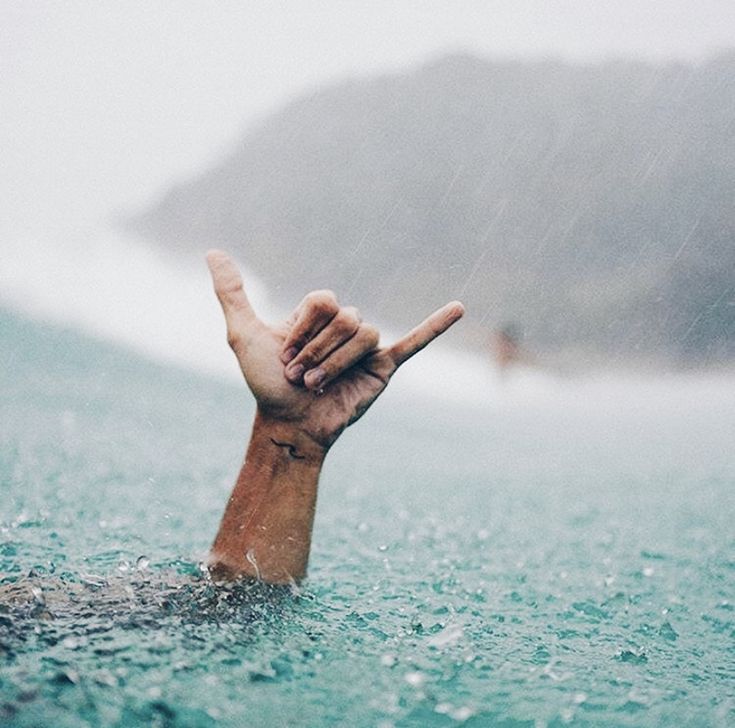 a person in the water holding their hand up