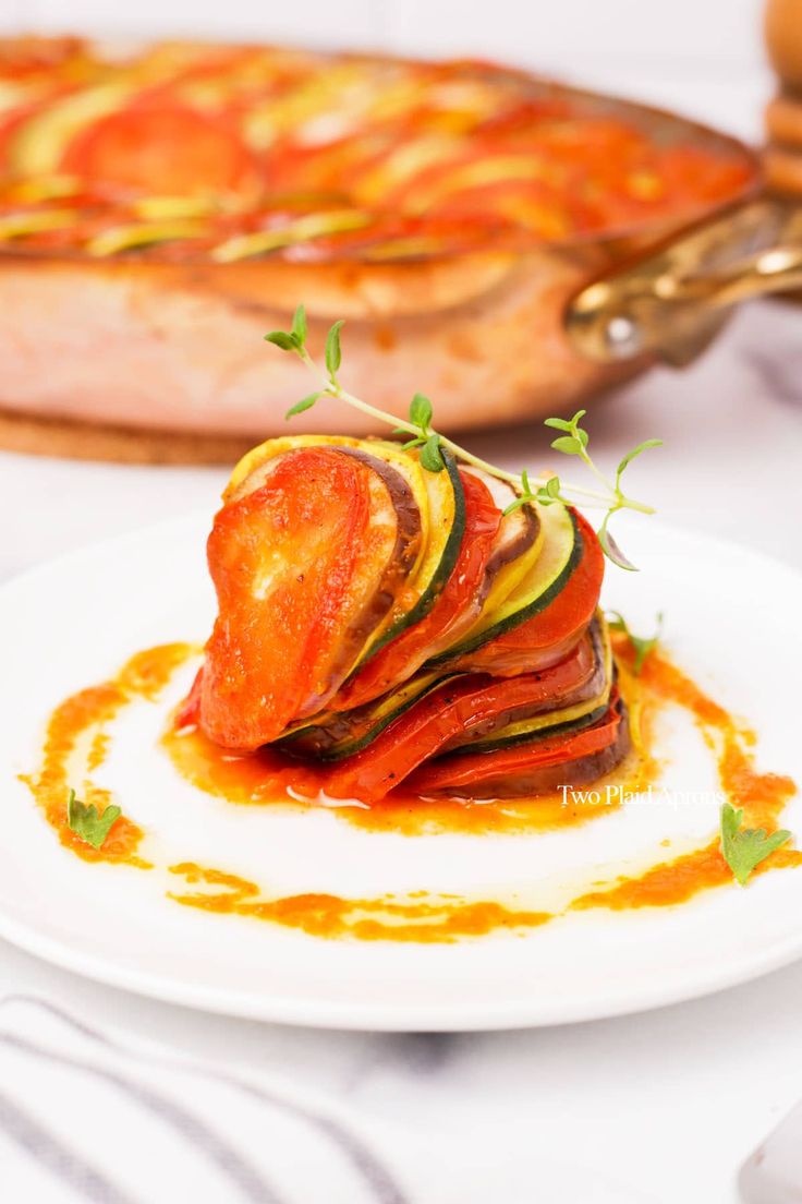 a white plate topped with sliced vegetables and sauce