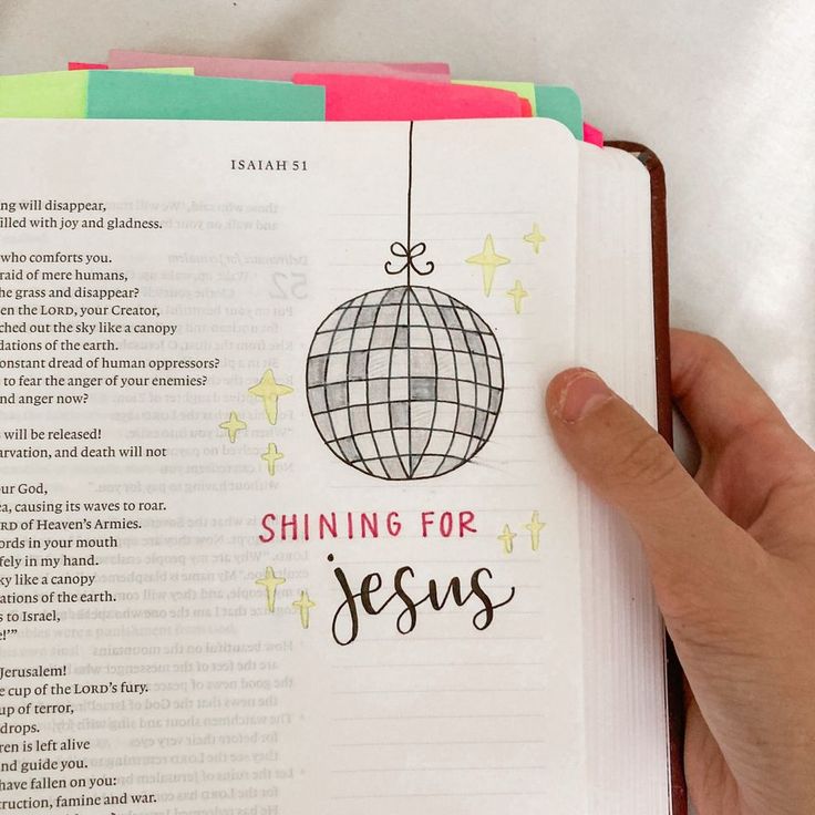 a hand holding an open bible with the words shining for jesus on it and a disco ball