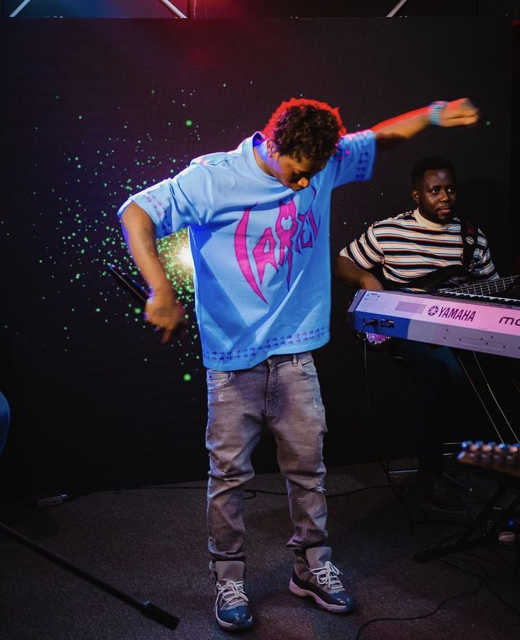 a young man standing on top of a keyboard