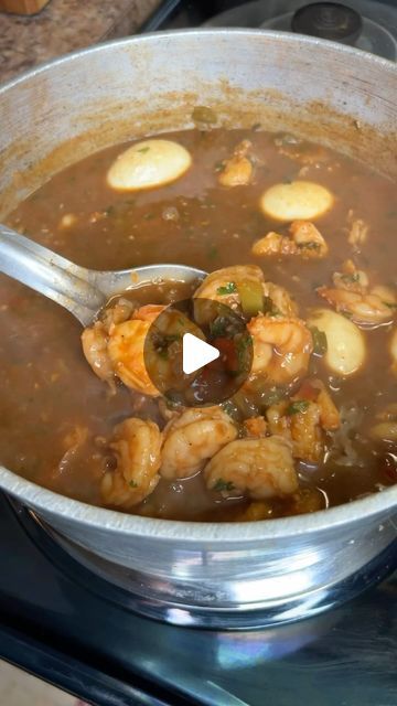 a pot filled with soup and shrimp on top of a stove