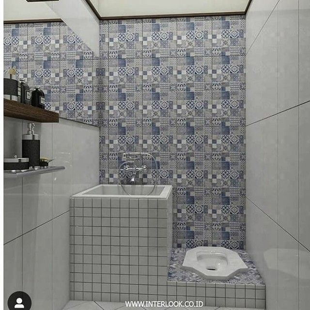 a bathroom with blue and white tiles on the walls