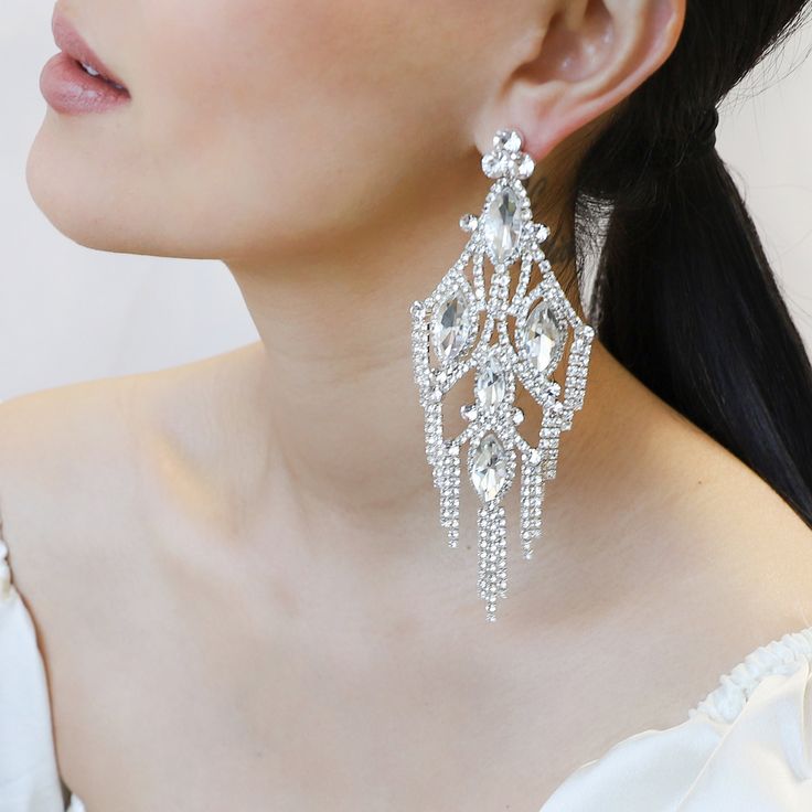 Fringe and flowy, these dazzling statement earrings pair well with tops that accentuate your neck and chest area. Size: - Post backing earrings. Length: 5 in (12.7 cm) x Width: 2 in (5.08 cm) Quality: - Large rhinestone gems lined with mini rhinestones accent in a chandelier design with metal alloy backing Imported ERY10193SCL Stunning Chandelier, Pearl Shop, Chandelier Design, Room Size, Pearl Set, Silver Drop Earrings, Pearl Ring, Chandelier Earrings, Shoulder Length