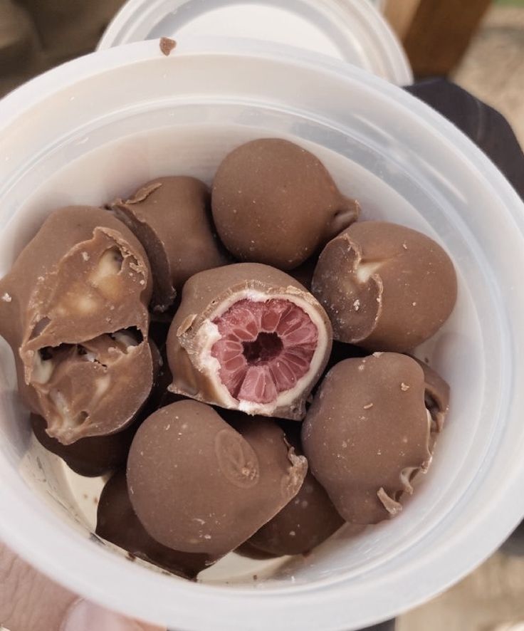 a white bowl filled with chocolate covered fruit