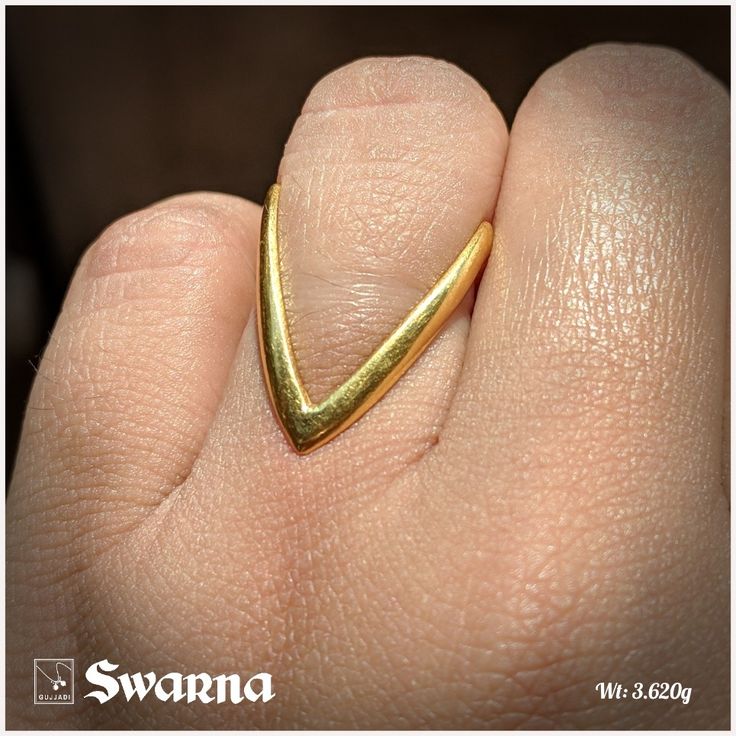 a person's hand with a gold ring on it