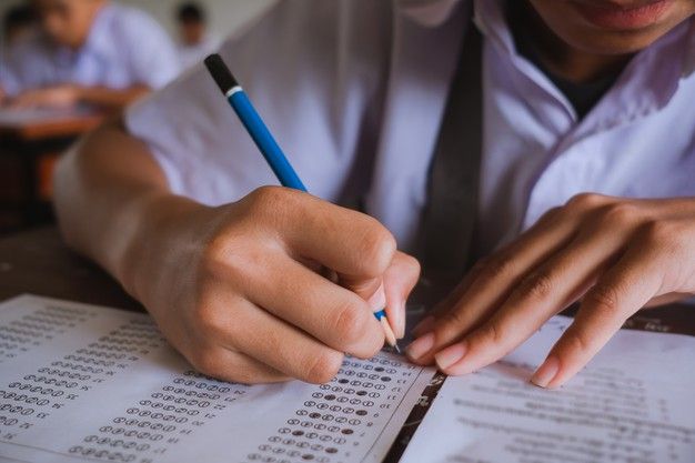 a person sitting at a desk writing on paper