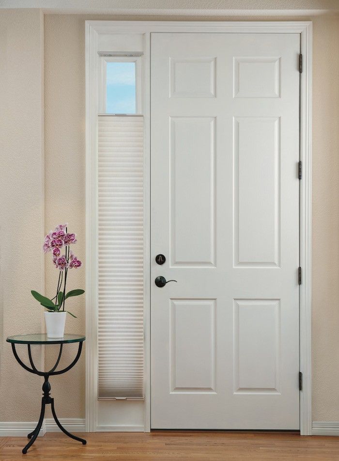 a vase with flowers on a table in front of a door