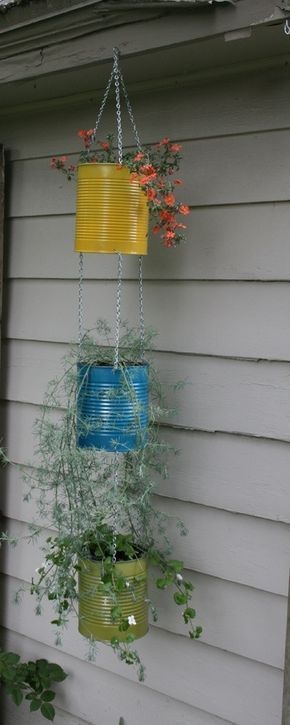 three hanging planters with plants in them on the side of a house