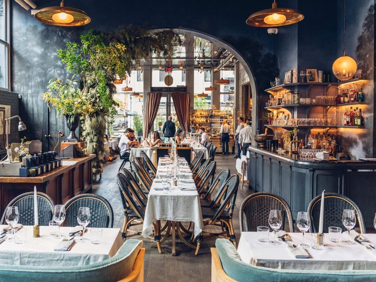 the interior of a restaurant with many tables and chairs