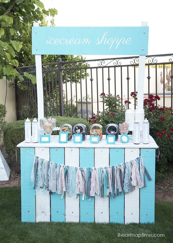 an ice cream shoppe is set up in the grass with blue and white decorations