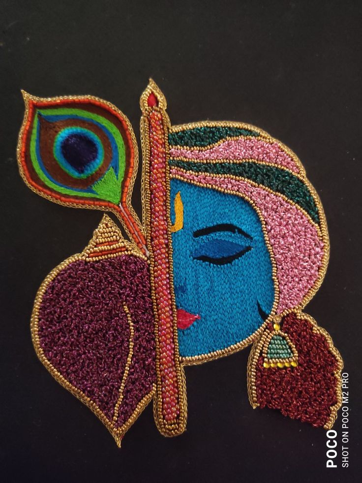 an embroidered patch with a woman's face and peacock feather on the back of it