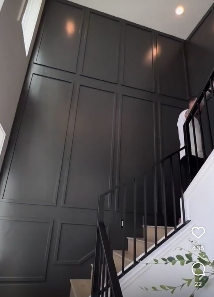 a man standing on top of a stair case next to a set of black stairs