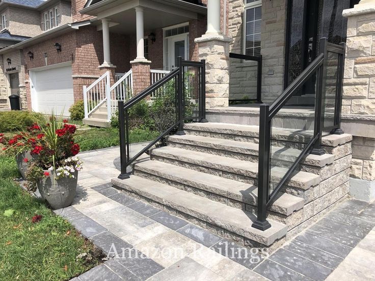 a house with stone steps leading to the front door and entry way, surrounded by flowers