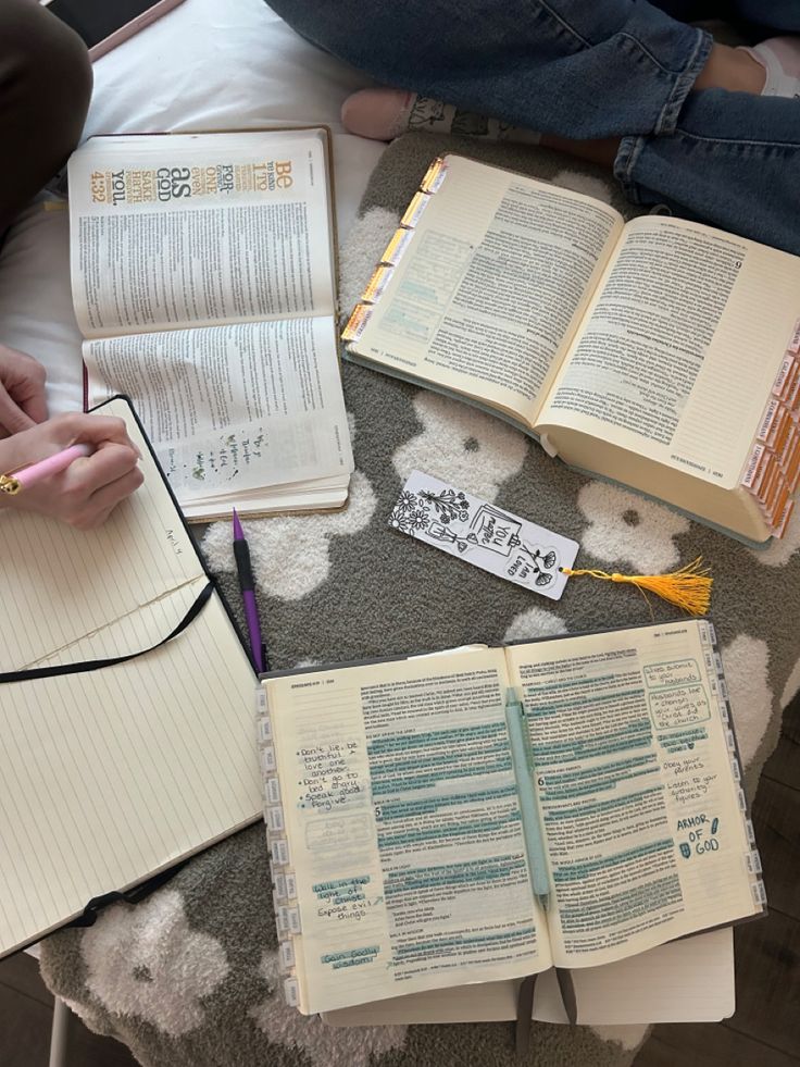 an open book on a table with two notebooks and some writing utensils