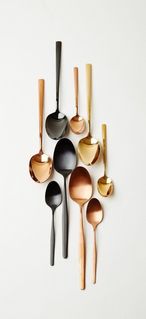 spoons and ladles are arranged on a white surface