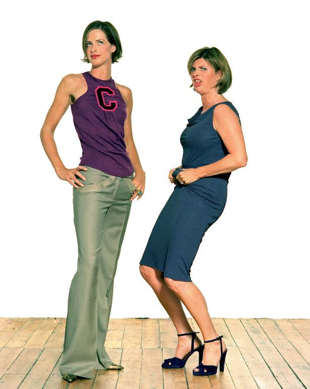 two women standing next to each other on a wooden floor