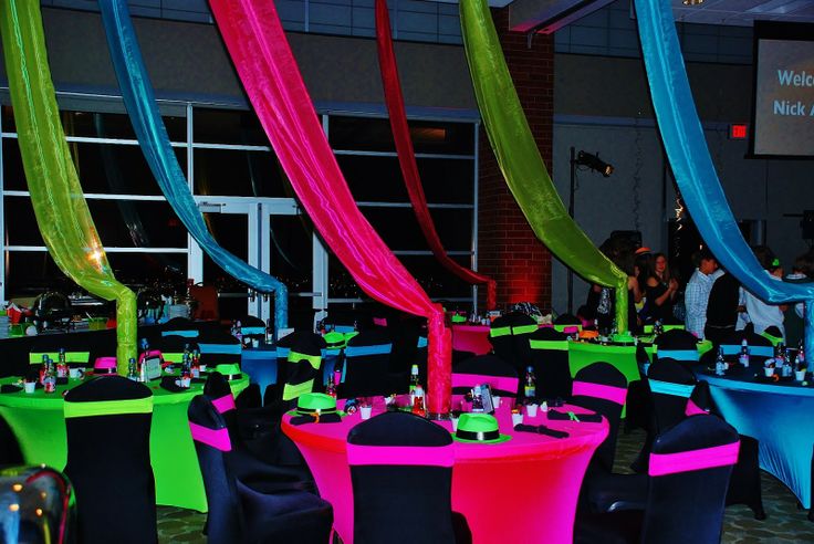 a room filled with lots of tables covered in colorful cloths