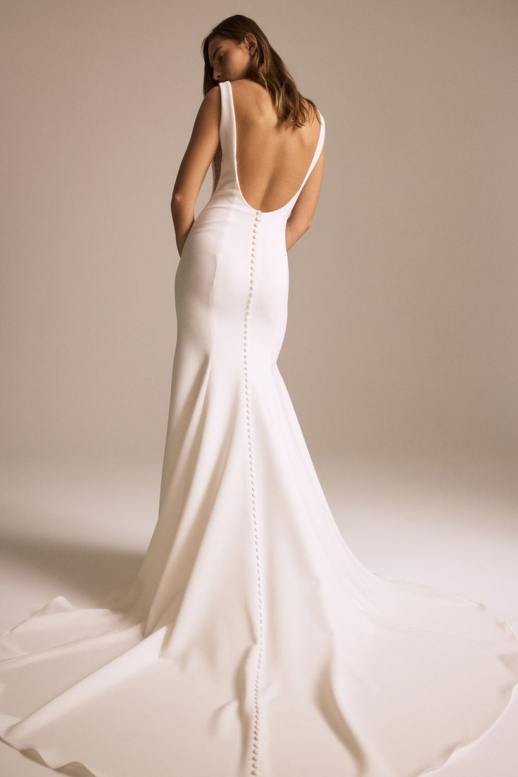 a woman in a white wedding dress is standing back to back with her hands on her hips